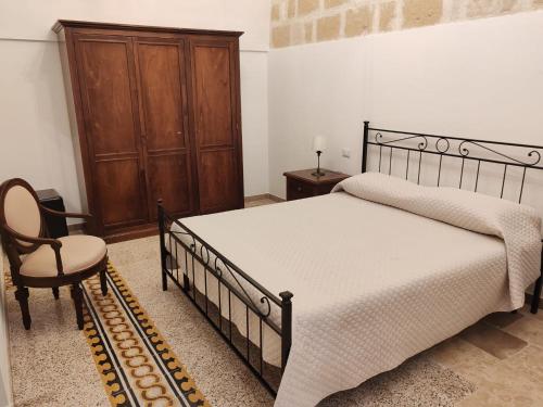 a bedroom with a large bed and a chair at Dimora '900 in Poggiorsini