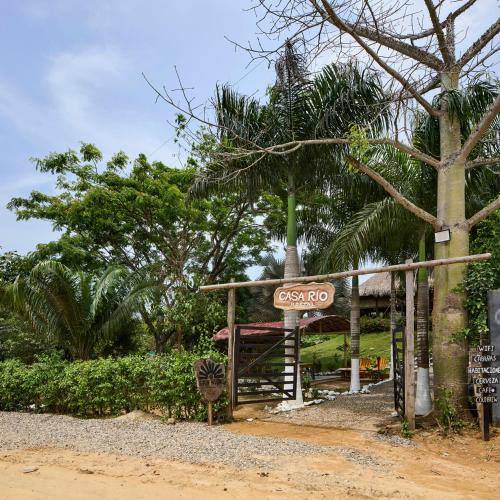 a sign for a gas station in front of trees at Bungalows Casa Rio Palomino in Palomino
