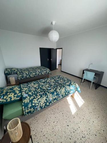 une chambre avec deux lits et un bureau dans l'établissement Maison 2 chambres 3 lits 4 couchages et extérieur, à Villefranche-de-Lauragais