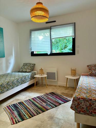 - un salon avec deux lits et une fenêtre dans l'établissement Maison en bois Lacanau centre, à Lacanau