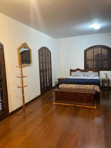 a bedroom with a bed and a mirror on the wall at Casa Estilo Colonial in Vassouras