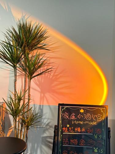 a chalkboard with a rainbow next to two palm trees at CANG 藏In山院 in Yangshuo