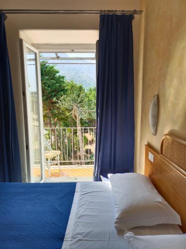 a bedroom with a bed and a sliding glass door at Relais Villa Raffaele by Emilia in Forio d'Ischia
