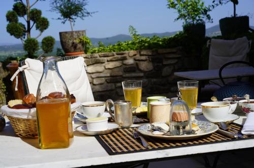 een tafel met een dienblad met eten en drinken erop bij MAISON D'HOTES LA GOURGUILLE in Barjac