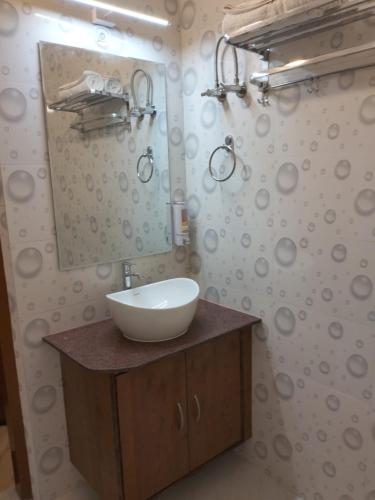 a bathroom with a white sink and a mirror at Happy Home Paying Guest House in Varanasi
