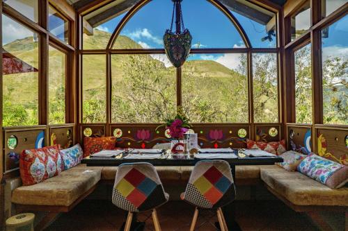 a dining room with a table and a large window at Twelve Hummingbirds Andes Retreat in Paute
