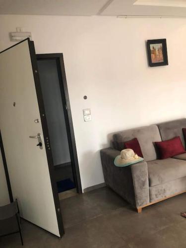a living room with a couch with a hat on a table at Appartement bord de mer in Chott Meriem