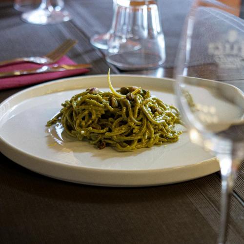 a plate of pasta sitting on a table at Marathon Hostel in Genova