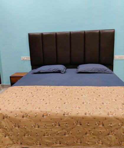 a bed with a brown comforter and two pillows at Deepak Homestay in Rishīkesh