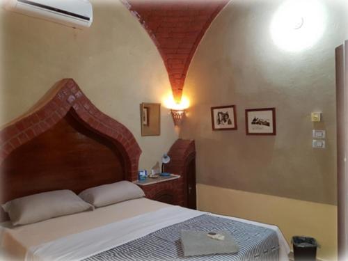 a bedroom with a large bed with an arch above it at Harmony Villas Sleeps 4 with Garden in Al Qurnah