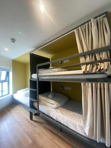 two bunk beds in a room with wooden floors at Heyday Hostel Ballina in Ballina