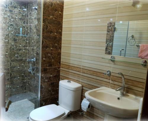 a bathroom with a toilet and a sink and a shower at Harmony Villas Sleeps 4 with Garden in Al Qurnah
