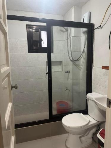 a bathroom with a shower with a toilet and a sink at Trail Bedz Homestay in Baguio