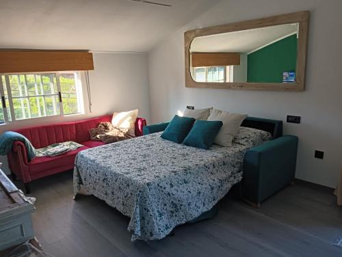 a bedroom with a bed and a red couch at Casa Duarte, Airiños de Xil in Meaño
