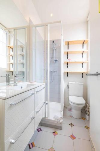 une salle de bain blanche avec douche et toilettes dans l'établissement Le Duplex Pernot, à Dijon