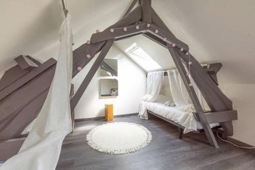 - une chambre mansardée avec un lit à baldaquin dans l'établissement Le Duplex Pernot, à Dijon