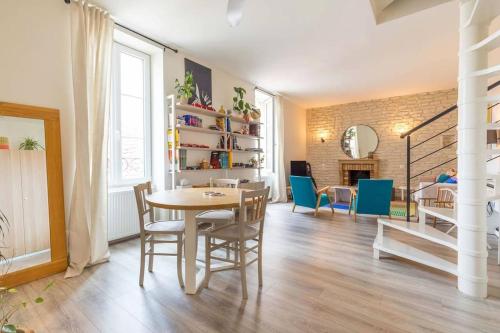 une salle à manger avec une table et des chaises et un salon dans l'établissement Le Duplex Pernot, à Dijon