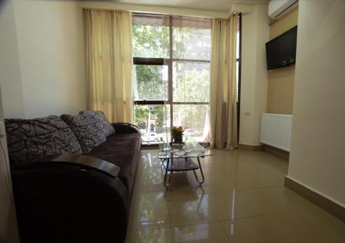 a living room with a couch and a table and a window at Hotel Premium Armenia in Yerevan