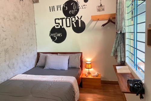 a bedroom with a bed and a sign on the wall at Trại Hoa Vàng Homestay at Phú Yên in Ðông Tác (1)