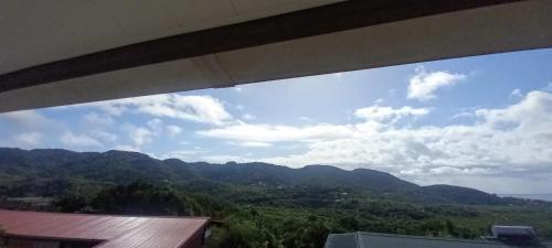 a view of a mountain range from a window at Maison charmante à Rivière-Pilote avec vue sur la montagne in Rivière-Pilote