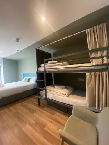 a room with two bunk beds and a chair at Heyday Hostel Ballina in Ballina