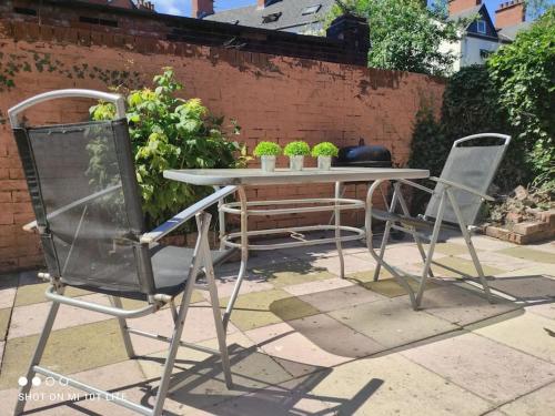 two chairs and a table with plants on it at Location! 2 bed city centre with free parking in Belfast