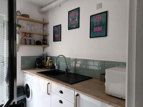 a kitchen with a sink and a washing machine at Location! 2 bed city centre with free parking in Belfast