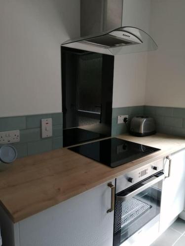 a kitchen with a counter with a stove top oven at Location! 2 bed city centre with free parking in Belfast
