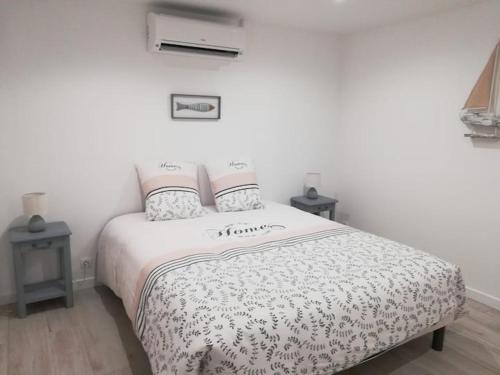 une chambre avec un lit et deux tables de nuit dans l'établissement Jolie Maisonnette de 37 m2 meublée, à Saint-Vincent-de-Tyrosse