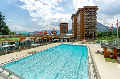 une piscine dans un hôtel avec des montagnes en arrière-plan dans l'établissement Appartement Cosy- Villarembert, à Villarembert