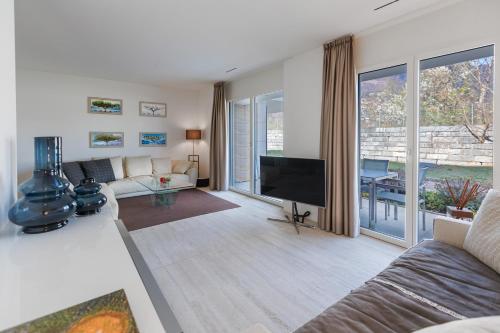 a living room with a couch and a flat screen tv at Suite Appartement 713 in Ascona