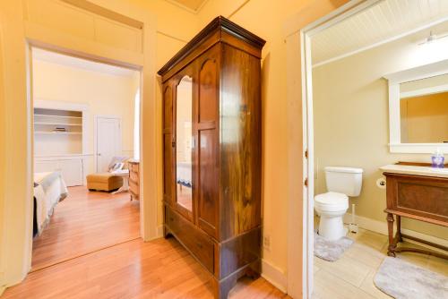 a bathroom with a toilet and a wooden cabinet at Cozy Thomasville Cottage - Walk to Downtown! in Thomasville