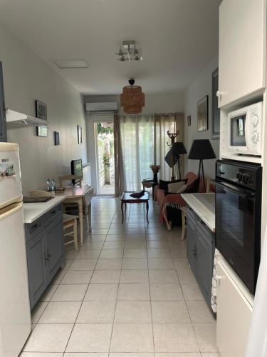 Il comprend une cuisine dotée de carrelage blanc et une salle à manger. dans l'établissement L’Annexe, à Arles