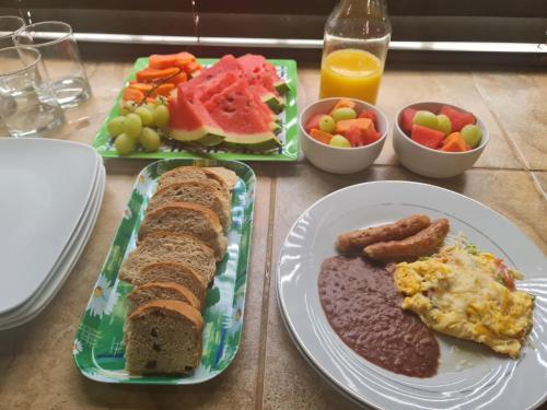 a table topped with plates of food with breakfast foods at GM Suites Bed & Breakfast in Belmopan