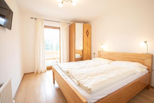 a bedroom with a large white bed with a window at Almhäuser Filzsteinalpe Almhaus 205 in Krimml