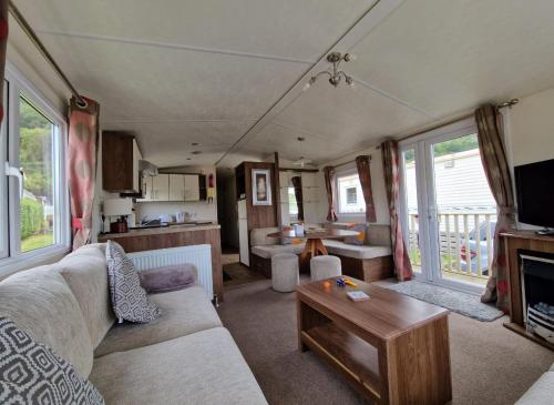 un soggiorno con un divano e un tavolo di Modern 2017 model Delta Sienna static caravan in Clarach Bay ad Aberystwyth