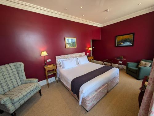 a bedroom with a bed and a couch and a chair at Buccleuch and Queensberry Arms Hotel in Thornhill