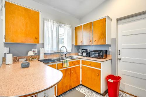 a kitchen with wooden cabinets and a counter top at 3 Mi to Michigan State Duplex with Patio in Lansing in Lansing