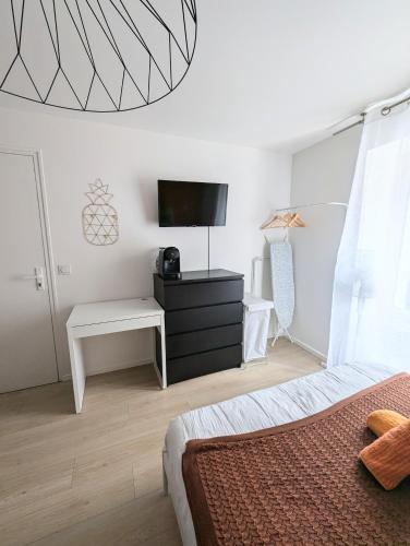 une chambre avec un lit et une télévision sur un mur dans l'établissement Studio cosy tout équipé proche de Genève, à Viry