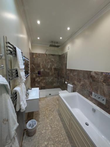 a bathroom with a tub and a sink at Buccleuch and Queensberry Arms Hotel in Thornhill