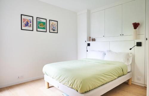 - une chambre blanche dotée d'un lit avec des draps jaunes dans l'établissement Beautiful central apartment near Eiffel Tower and Invalides, à Paris