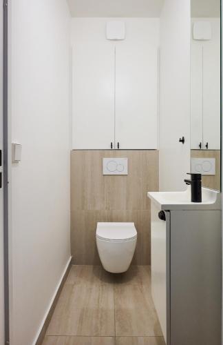 une salle de bain blanche avec des toilettes et un lavabo dans l'établissement Beautiful central apartment near Eiffel Tower and Invalides, à Paris