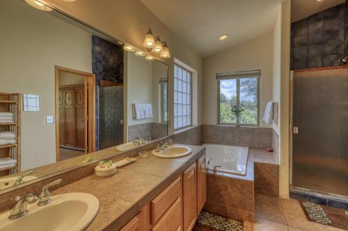 a bathroom with two sinks and a shower and a tub at 460 Hills Circle in Nutria