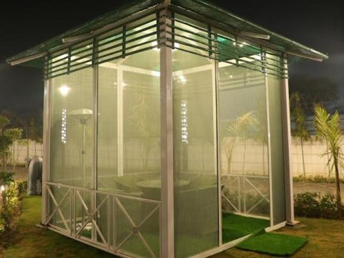 a large glass greenhouse with a table in it at Bhatia Farms in Samālkha