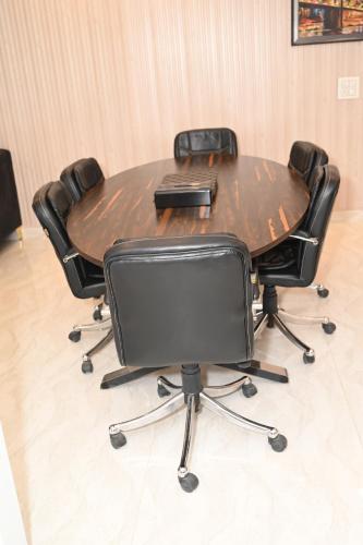 a conference room table with four chairs around it at Bhatia Farms in Samālkha