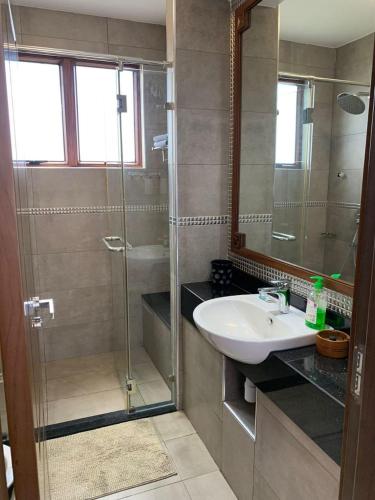 een badkamer met een glazen douche en een wastafel bij Luxurious Beachfront Villa with Private Pool - Sultan Palace in Kilifi