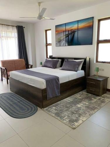 een slaapkamer met een groot bed en een bank bij Luxurious Beachfront Villa with Private Pool - Sultan Palace in Kilifi