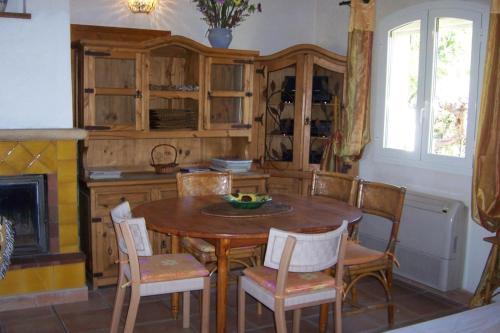 une cuisine avec une table et des chaises ainsi qu'une cheminée dans l'établissement Le gite les amandiers, à Laouque