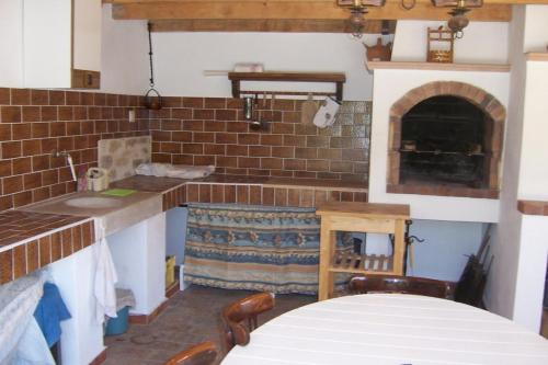 - une cuisine avec une cheminée et une table dans une chambre dans l'établissement Le gite les amandiers, à Laouque