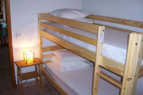 un lit superposé avec une lampe sur une table de nuit dans l'établissement Le gite les amandiers, à Laouque